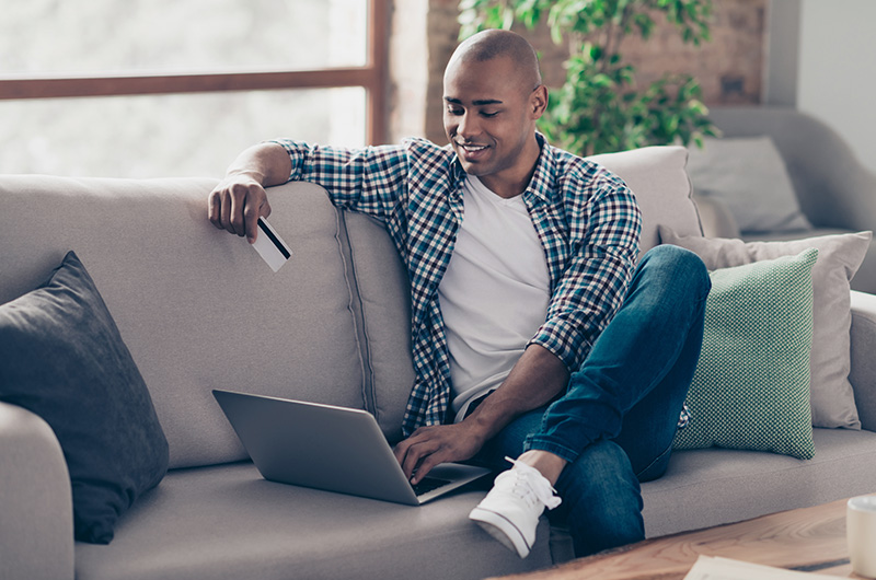 man online shopping on sofa